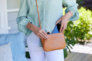 Leather crossbody wallet with phone and sunglasses showing