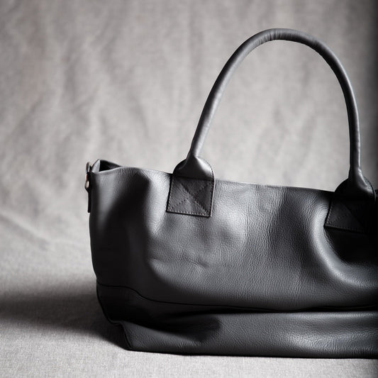 Grey
leather handbag on a textured gray background