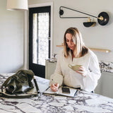 Woman at kitchen bench with Rome in Army on bench beside her.