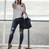 Woman standing by a waterfront with a Paris black leather tote